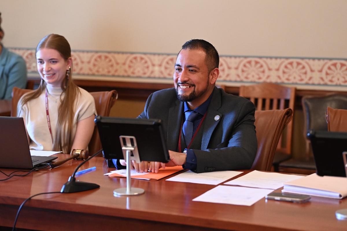 State Senator Javier Loera Cervantes smiles while sitting in a Senate committee meeting